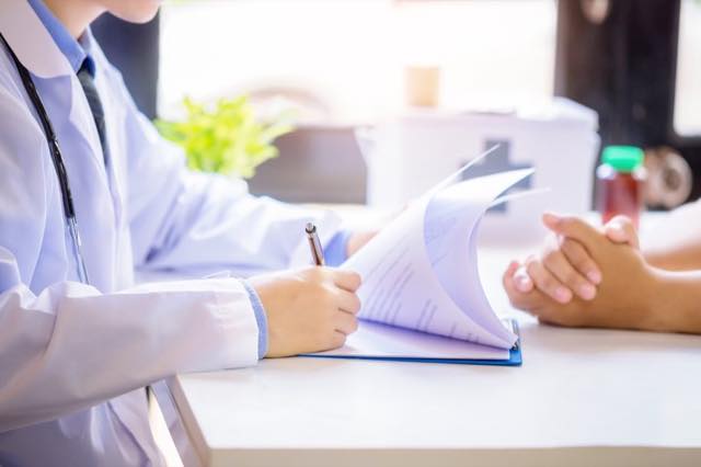 doctor-man-consulting-patient-while-filling-up-application-form-desk-hospital.jpg